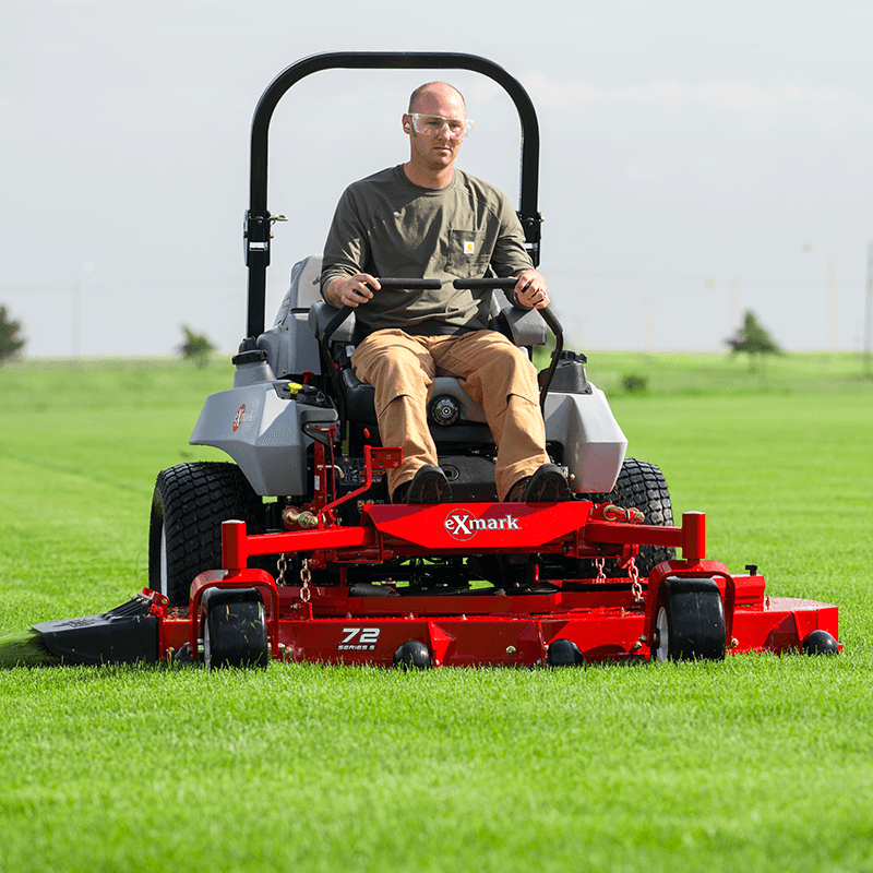 Lawn Service Professional sitting on an Exmark riding lawnmower.